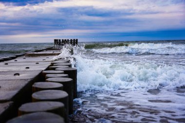 Yüksek ve çalkantılı bir deniz dalgası büyük dalgalara çarpar ve kırılır..                    