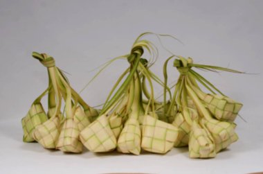 Arka plan için ketupat (beyaz zemin üzerinde pirinç köftesi). Ketupat, bayram bayramında pilav pişirmek için taze hindistan cevizi yapraklarından yapılan doğal bir pirinç kabıdır. Metin kartı tasarımı için boşluk kopyala, izole edilmiş beyaz arkaplan