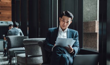 Kahve dükkanında otururken Belgeleri analiz eden Ciddi İşadamı