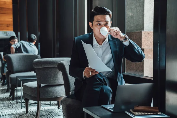 Jóképű Üzletember Kávét Iszik Miközben Egy Kávézóban Egy Laptoppal Dokumentumokkal — Stock Fotó