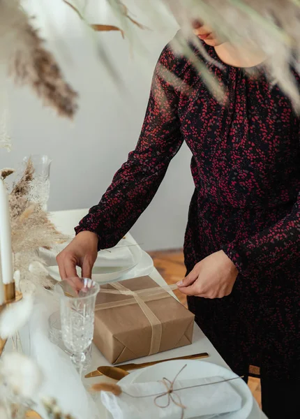 匿名の女性がエレガントなディナーパーティーを開催し クリスマスプレゼントを作る ロイヤリティフリーのストック画像