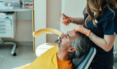 Yaşlanma Karşıtı Tedavi: Ciddi yetişkin bir adamın klinikte botoks yaptırırken yüksek açılı görüntüsü