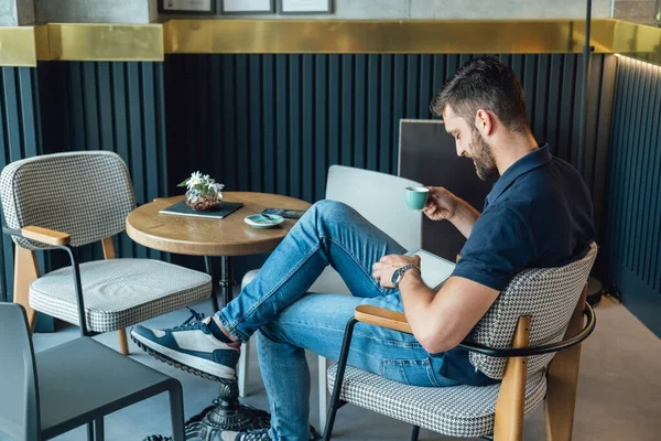 コーヒーを飲みながらコーヒーショップに座っている間 彼のデジタルタブレット上のビジネスレポートを読んで笑顔男の高い角度ビュー ストック写真
