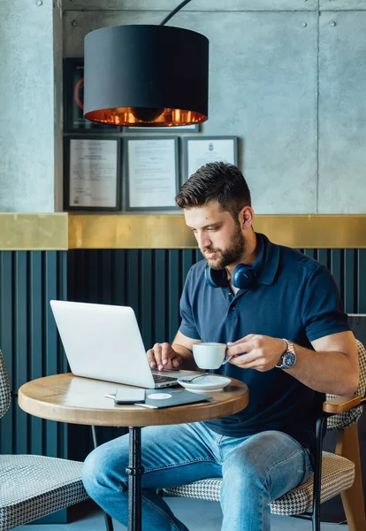 カフェでノートパソコンを操作するシリアスビジネスマン ロイヤリティフリーのストック写真