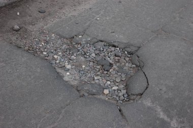 Kırık asfalt, yolda bir çukur.