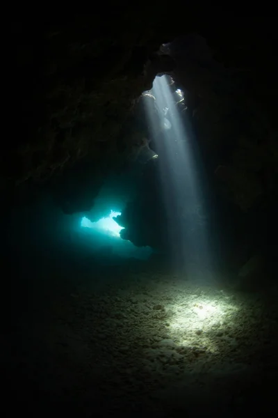 太陽の光のビームは サンゴ礁の穴を通ってフィジーの水没した洞窟に降ります 岩礁はしばしば狭い亀裂 洞窟に浸食される — ストック写真