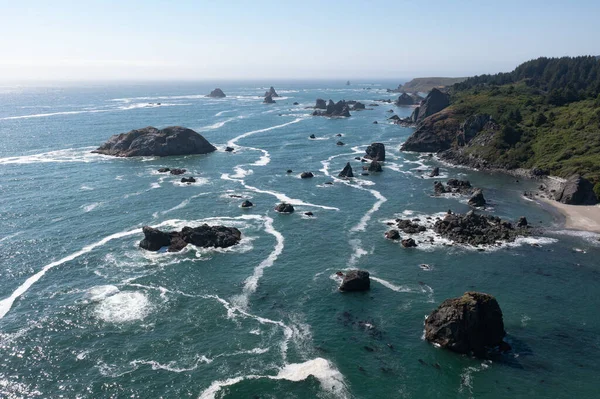 The Pacific Ocean washes against the beautiful coastline of southern Oregon near Brookings. This part of the Pacific Northwest is known for its rugged scenery of forests and ocean.