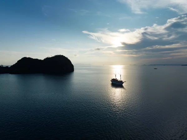 日の出は ラジャ アンパットの美しい海から昇る劇的な石灰岩の島を照らし出します インドネシアのこの遠隔地は信じられないほどの海洋生物多様性で知られています — ストック写真