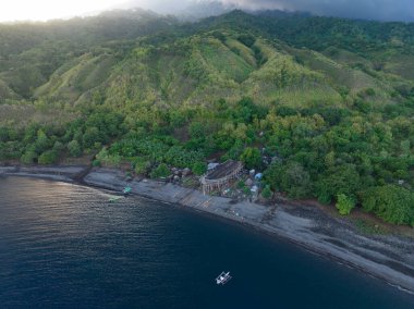 Endonezya 'daki Komodo Ulusal Parkı yakınlarındaki Sangeang adasından uzak, volkanik bir ada yükselir. Bu güzel ada, siyah kum deniz habitatlarıyla ünlüdür..
