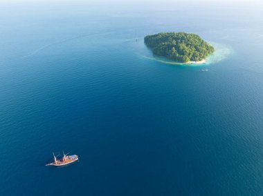 Raja Ampat 'ın Dampier Boğazı' nda, mercan resifleriyle çevrili, huzurlu, tropik bir ada bulunur. Bu bölge inanılmaz deniz biyolojik çeşitliliği nedeniyle Mercan Üçgeni 'nin kalbi olarak bilinir..