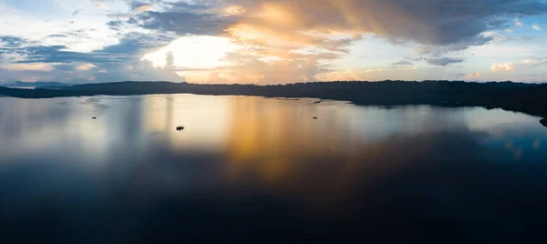 stock image A serene sunrise illuminates the calm seas of Raja Ampat, Indonesia. This remote, equatorial region is known for its high marine biodiversity and is a popular destination for diving and snorkeling.