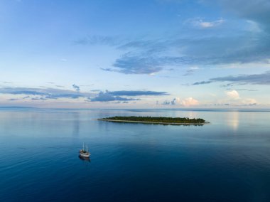 Sabahın erken saatlerinde Endonezya, Seram yakınlarındaki uzak Koon adasını aydınlatır. Bu manzaralı adanın mercan resifleri ve çevreleyen denizler olağanüstü deniz biyolojik çeşitliliğini destekler..