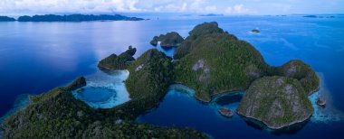 Raja Ampat 'ın tropikal deniz manzarasından güzel kireçtaşı adalar yükselir. Endonezya 'nın bu bölgesi, orada bulunan olağanüstü deniz biyolojik çeşitliliği nedeniyle Mercan Üçgeni' nin kalbi olarak bilinir..