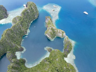 Resiflerle çevrili Balbalbalol 'un kireçtaşı adaları, Raja Ampat' ın tropikal deniz manzarasından yükselir. Bu bölge, Mercan Üçgeni 'nin kalbi olarak bilinir. Orada bulunan yüksek deniz biyolojik çeşitliliği nedeniyle..