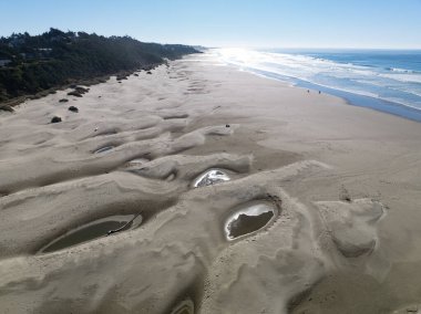 Bright sunlight shines on Agate Beach situated along the Oregon Coast Highway in the town of Newport. The beautiful beach is named after its abundance of iron oxide-colored agates found there. clipart