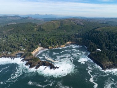 Pacific Ocean waves crash against the rugged coastline of Oregon, not far south of Lincoln City. This part of the Pacific Northwest coast is incredibly scenic and accessed from highway 101. clipart