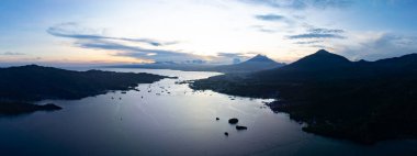 Kuzey Sulawesi 'yi Lembeh Adası' ndan ayıran güneş Lembeh Boğazı 'nın üzerinde batar. Bu tropikal alan deniz biyolojik çeşitliliğinin bolluğuna ev sahipliği yapar ve dalgıçlar arasında popülerdir..