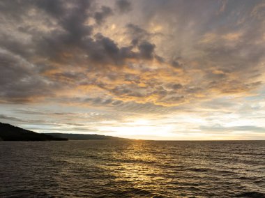Manado, Kuzey Sulawesi, Endonezya yakınlarındaki Pasifik Okyanusu üzerinde güzel ve renkli bir günbatımı meydana gelir. Bu bölge dalgıçlar ve şnorkelciler için popüler bir yerdir..