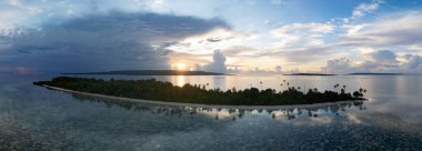 Sulawesi açıklarındaki Wakatobi Ulusal Parkı 'nda sakin bir gün doğumu silueti var. Bu bölge, yüksek deniz biyolojik çeşitliliği nedeniyle dalgıçlar ve şnorkelliler için popüler bir yerdir..