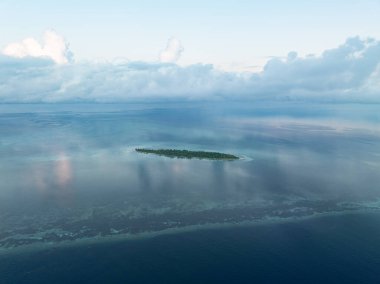 Akşam ışığı Sulawesi açıklarındaki Wakatobi Ulusal Parkı 'nda bir adayı aydınlatıyor. Bu bölge, yüksek deniz biyolojik çeşitliliği nedeniyle dalgıçlar ve şnorkelliler için popüler bir yerdir..