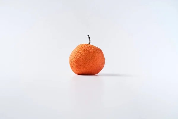 Kurumuş mandalina. Çürük narenciye meyvesi izole edilmiş. Clementine 'ın derisi buruşmuş..                               