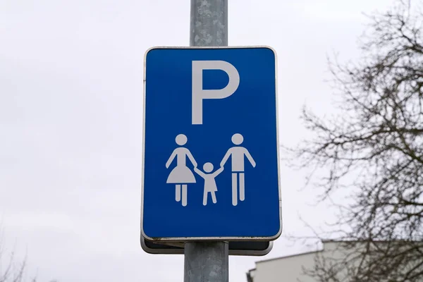 Traffic sign with the information that the parking lot is only allowed for families with children. Blue parking sign with mother, father and child. Family friendly parking.