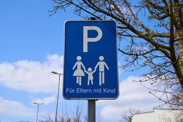 Trafik levhasında otoparkın sadece çocuklu ailelere izin verildiği yazıyor. Anne, baba ve çocuğun mavi işareti. Aile dostu park yeri.             