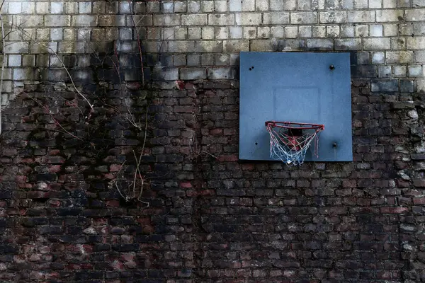 Eski bir duvarda eski bir basketbol potası.