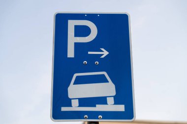 Bir kaldırım park levhası. Yol işaretindeki bir ok sağ tarafı gösteriyor. Tabelada 