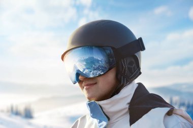 Kar Dağları 'nın yansıması olan bir adamın kayak gözlüklerine yakın çekim. The Background Blue Sky 'daki Snowboardcu adam. Kış Sporları