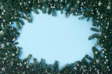 Kesme tahtası yeşil Noel ağacı dallarının arka planında yer alıyor. Köknar dalları ve çam kozalaklarından yapılmış çerçeve. Yeni Yıl ve Noel kavramı. Süper manzara..