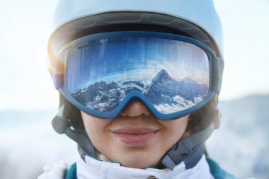 Kar Dağları 'nın yansıması olan bir kadının kayak gözlüklerini kapatın. Kar Maskesine Yansıyan Dağ Sırası. Kış Sporları.