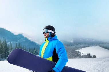 Kayak merkezindeki snowboardcu. Arka plandaki mavi gökyüzünde. Snowboard yapma. Kayak gözlüğü takıyor. Kar Dağlarının Yansımasıyla Kayak Gözlükleri