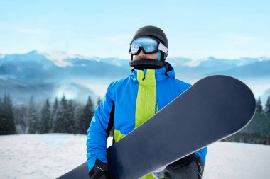 Kayak merkezindeki snowboardcu. Arka plandaki mavi gökyüzünde. Snowboard yapma. Kayak gözlüğü takıyor. Kar Dağlarının Yansımasıyla Kayak Gözlükleri.