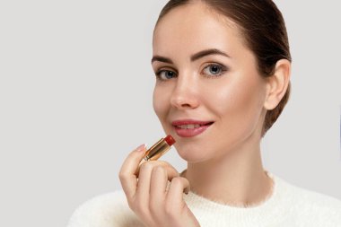 Dudaklarını kızartan çekici kızın yakın portresi. Kırmızı Ruj Tutan Kadın.