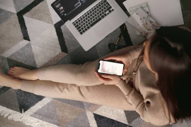 Akıllı telefon kullanan bir kadın. Ödeme. İnternetten alışveriş konsepti. Evde çalışıyorum. Karantina ve Sosyal Mesafe