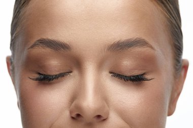 Kaşlı genç bayan, yaklaşın. Kapalı gözlü bir kadın yüzü. Makyaj.