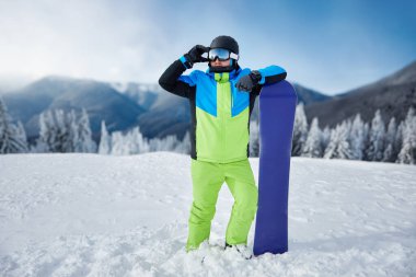  Karpat Dağları 'ndaki snowboardcu portresi, Bukovel Snowboardcusu. Kar maskesine yansıyan bir dağ sırası. kayak gözlüğü takıyor