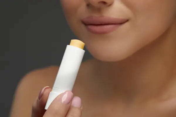 Lip Care Stick.  Closeup Of Female Face With Soft Skin Putting Lip Protector Lipstick On. Lips Skin Care. Beautiful Woman Face With Sexy Full Lips Applying Hygienic Lip Balm