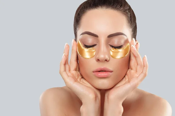 Beautiful Woman With Healthy Perfect Skin Holds Patches. Beauty Face With Gold Cosmetics Collagen Hydrogel Patch. Lifting Anti-Wrinkle Mask Under Eyes. Skin Care Concept.
