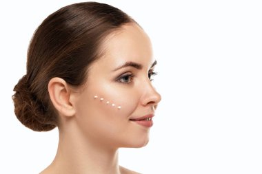 Taze derisi ve yüz kremi sürmüş uzun kirpikli güzellik modeli. Gençlik ve Deri Bakımı Konsepti. Spa ve Sağlık. Makyaj ve saç. Kırbaçlar.