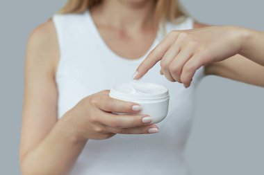 Krem tutarak ve nemlendirici el kremi uygulama kadın el closeup çekim. Güzel eller krema ile. El Cilt Bakımı. Bir kadının vücut losyonu kollarında kullanır. Güzellik ve vücut bakım kavramı