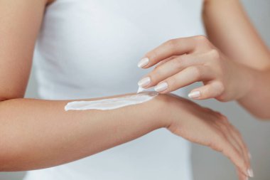 Krem tutarak ve nemlendirici el kremi uygulama kadın el closeup çekim. Güzel eller krema ile. El Cilt Bakımı. Bir kadının vücut losyonu kollarında kullanır. Güzellik ve vücut bakım kavramı