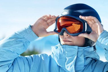 Bir adam kayak gözlük dağlara kar yağdı yansıması ile kapatın. Bir dağ kar maskesi yansıtıyordu. Dağlar ve gökyüzü arka plan üzerinde kayak merkezi bir adam portresi