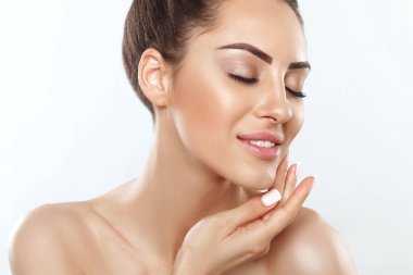 Beautiful smiling woman with healthy smooth facial clean skin applying cosmetic cream and touch own face. Model with  Beauty face. Skin care Moisturizer Facial treatment. Cosmetology. Spa.