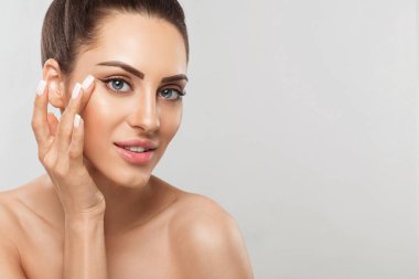 Beauty face model. Beautiful Woman with healthy smooth facial clean skin holding bottle cosmetic cream. Face Skin care Moisturizer Facial treatment. Cosmetology. Dermatology. Spa.