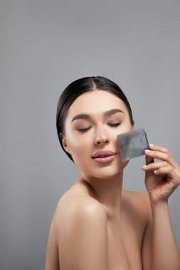 Kadın, lekeleme kağıtları kullanarak yüzünden yağ çıkarıyor. Cilt Bakımı. 