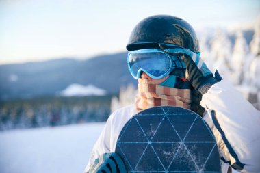 Snowboard tutan ve kayak gözlüğü takan bir kadının portresi. 