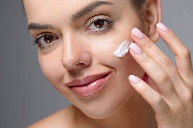 Güzel, sağlıklı tenli kadınlar yüz estetiği stüdyo resmine dokunuyor..