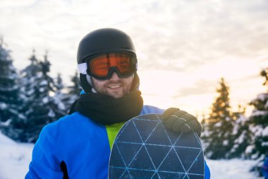 Gülümseyen Snowboardcu Kış Dağı manzarasında Açık Hava Pozisyonu Verdi.